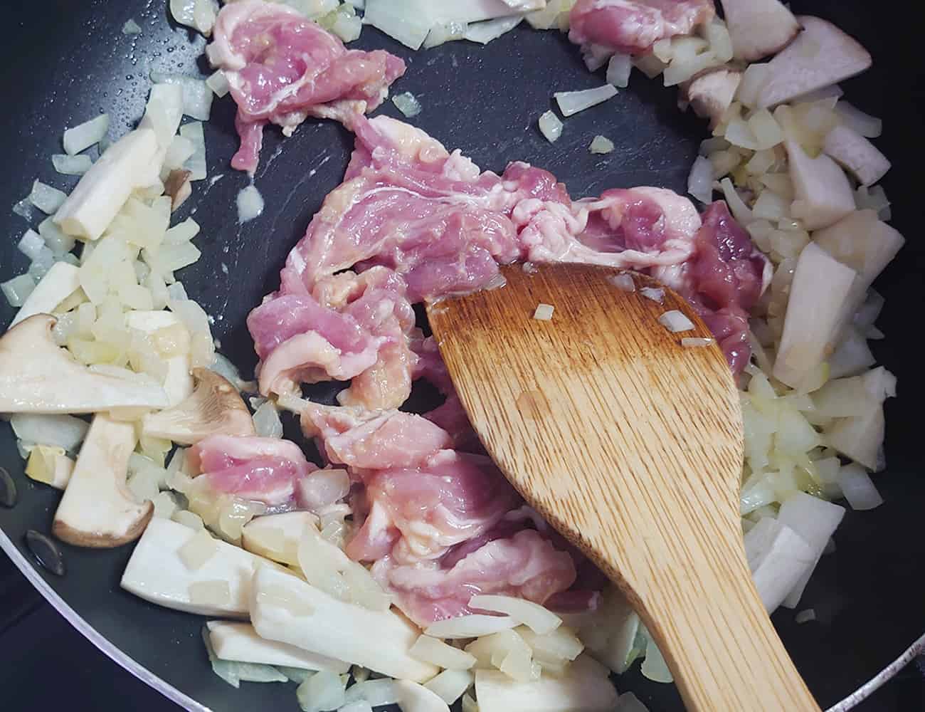 エリンギがしんなりしたら、豚肉を入れてさらに炒める。