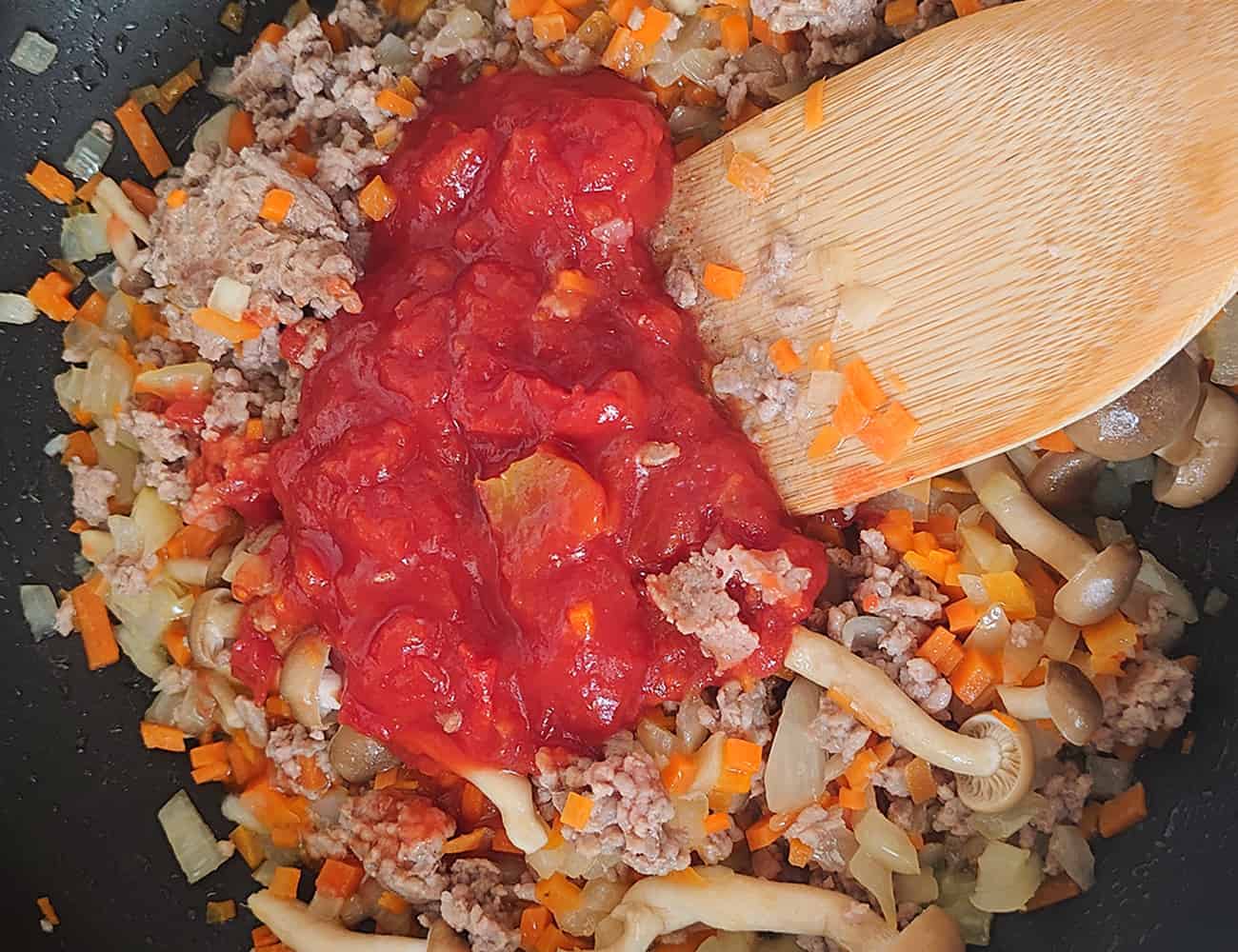 ひき肉に火が通ったら、カットトマト、コンソメを入れて炒める。